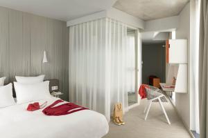 a bedroom with a bed and a chair at Okko Hotels Paris Porte De Versailles in Paris