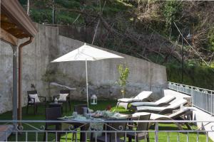 un patio con mesa, sillas y sombrilla en Casa Rosanna en Maiori