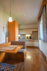 a living room with a wooden table and a kitchen at Residence Rebgut in Tesimo