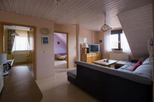 a living room with a couch and a tv at Ferienwohnung Arnold in Burkardroth