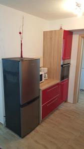 una cucina con armadi rossi e frigorifero di Apartment Rose a Pola (Pula)