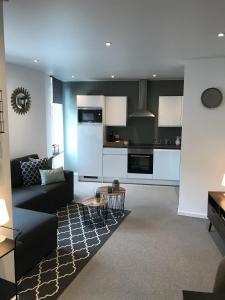 a living room with a couch and a kitchen at Le Coin Cocoon Inn in Aywaille