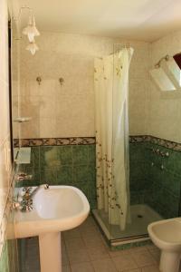 Reyes的住宿－Pura Vida Hosteria，浴室配有水槽、淋浴和浴缸。