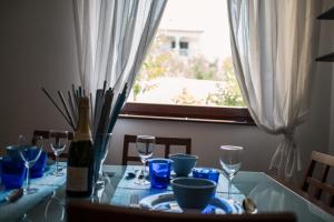 a dining room table with a bottle of wine and glasses at Apartment with private pool and arbor in Malinska
