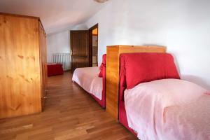 1 dormitorio con 2 camas y armario de madera en Albergo Diffuso "Col Gentile" Socchieve, en Priuso