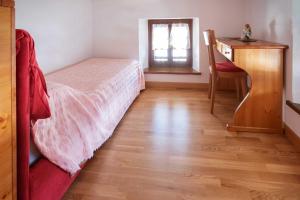 1 dormitorio con cama, escritorio y mesa en Albergo Diffuso "Col Gentile" Socchieve, en Priuso