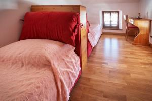 1 dormitorio con 1 cama y suelo de madera en Albergo Diffuso "Col Gentile" Socchieve, en Priuso