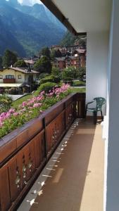 un banco sentado en un balcón con vistas a las flores en Villa Ginestra en Molveno