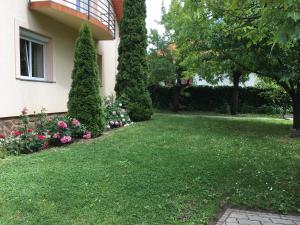 a yard in front of a house with flowers at Lavender Apartment in Siófok