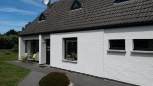 a white house with yellow chairs and a window at Aux doux Becots - Bed & Breakfast in Hardelot-Plage
