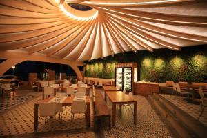 a restaurant with tables and chairs and a ceiling at Canyelles Platja in Roses