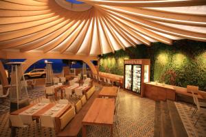 a restaurant with tables and chairs under a tent at Canyelles Platja in Roses