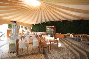 a restaurant with wooden tables and chairs and a tent at Canyelles Platja in Roses