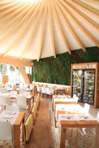 a restaurant with wooden tables and white chairs at Canyelles Platja in Roses