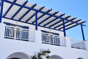 a white building with blue railing and a balcony at Bungalows Marina in Naousa