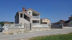 una casa bianca con una recinzione di fronte di Apartment Rose a Pola (Pula)