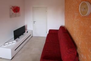 a living room with a red couch and a tv at Apartment Valmas in Pula