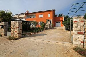 an orange house with a driveway in front of it at Apartment Valmas in Pula