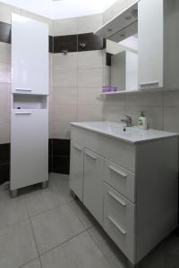 a white kitchen with a sink and a mirror at Apartment Valmas in Pula