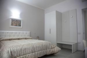 マテーラにあるSassi Vacanzeの白いベッドルーム(ベッド1台、テーブル付)