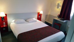 een hotelkamer met een groot bed met 2 kussens bij Fasthotel Tarbes Séméac - Un hôtel FH Confort in Séméac