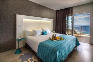 a hotel room with a bed with a tray of fruit on it at ESTIMAR Calpe Suitopia in Calpe