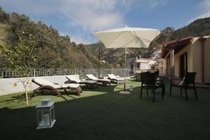 a group of chairs and an umbrella on a patio at Casa Rosanna in Maiori