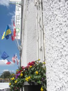 a pot of flowers next to a building with flags at Hostel Florenc in Prague