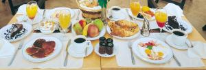 アテネにあるセオクセニア パレスの朝食用の食品とドリンクの盛り合わせが備わるテーブル