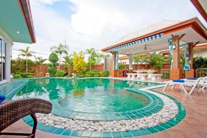 a swimming pool in the middle of a house at Victoria Villa in Na Jomtien