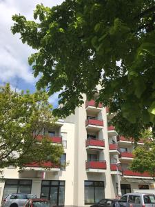 ein hohes weißes Gebäude mit roten Balkonen darauf in der Unterkunft Moderne Oase in Karlsruhe in Karlsruhe