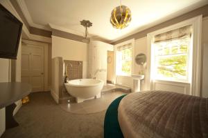 a large bathroom with a tub and a bed at Kilmore Country House in Glenariff