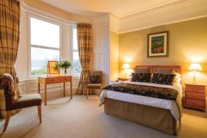 una camera d'albergo con letto e finestra di The Arran Lodge & Arran Sleep Huts a Lamlash