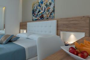 a bedroom with a bed and a bowl of fruit on a table at Artemide Hotel in San Vito lo Capo