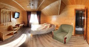 Cette chambre comprend un lit, une chaise et une télévision. dans l'établissement Yeva, à Mykulychyn
