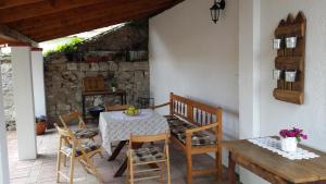 a patio with a table and chairs and a stone wall at Helló Bogács in Bogács