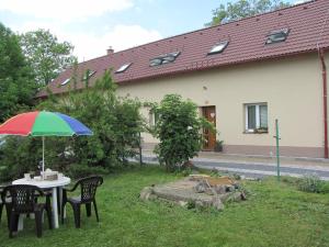 a table and chairs with an umbrella in a yard at Rivendell Apartments in Prague