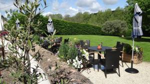 a garden with a table and chairs and an umbrella at The Colesbourne Inn in Colesbourne