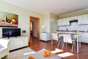 a kitchen with white cabinets and a table with chairs at Cecilia Apartments - stunning sea views and relaxing Mediterranean getaway in Lun