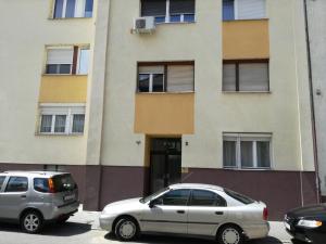 ブダペストにあるErőd Apartmentの建物前の駐車場に駐車した車2台