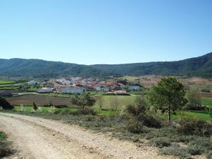 a dirt road with a village in the distance at Alojamiento Rural Sierra Luz in Ribatajadilla