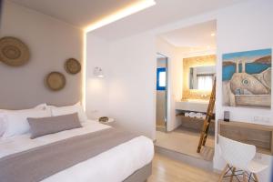 a bedroom with a large bed and a mirror at Louis Studios Santorini in Kamari