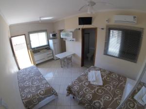 Habitación pequeña con cama y cocina en Áries Apart Hotel, en Bauru