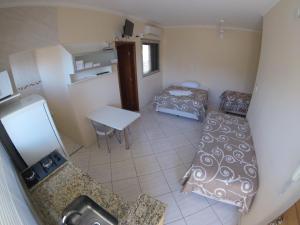 a small room with a bed and a table at Áries Apart Hotel in Bauru