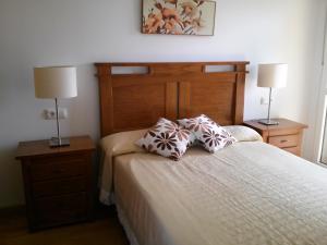 sypialnia z łóżkiem z dwoma szafkami nocnymi i dwiema lampami w obiekcie Apartamento Dicar w mieście Foz