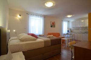 Un dormitorio con una cama grande y una cocina. en Apartment Casa Nova, en Rovinj