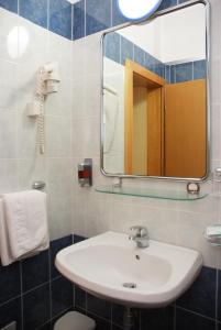 a bathroom with a sink and a mirror at Hotel Cubic in Laktaši