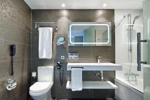 a bathroom with a toilet, sink, and bathtub at Vincci Gala in Barcelona