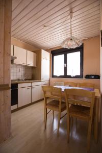 eine Küche mit einem Tisch, Stühlen und einem Kronleuchter in der Unterkunft Ferienwohnung Arnold in Burkardroth