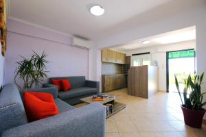 a living room with two couches and a table at PanDora Apartments in Moúdhros